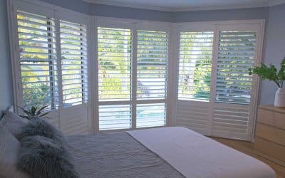 luxury white indoor plantation shutters in bedroom